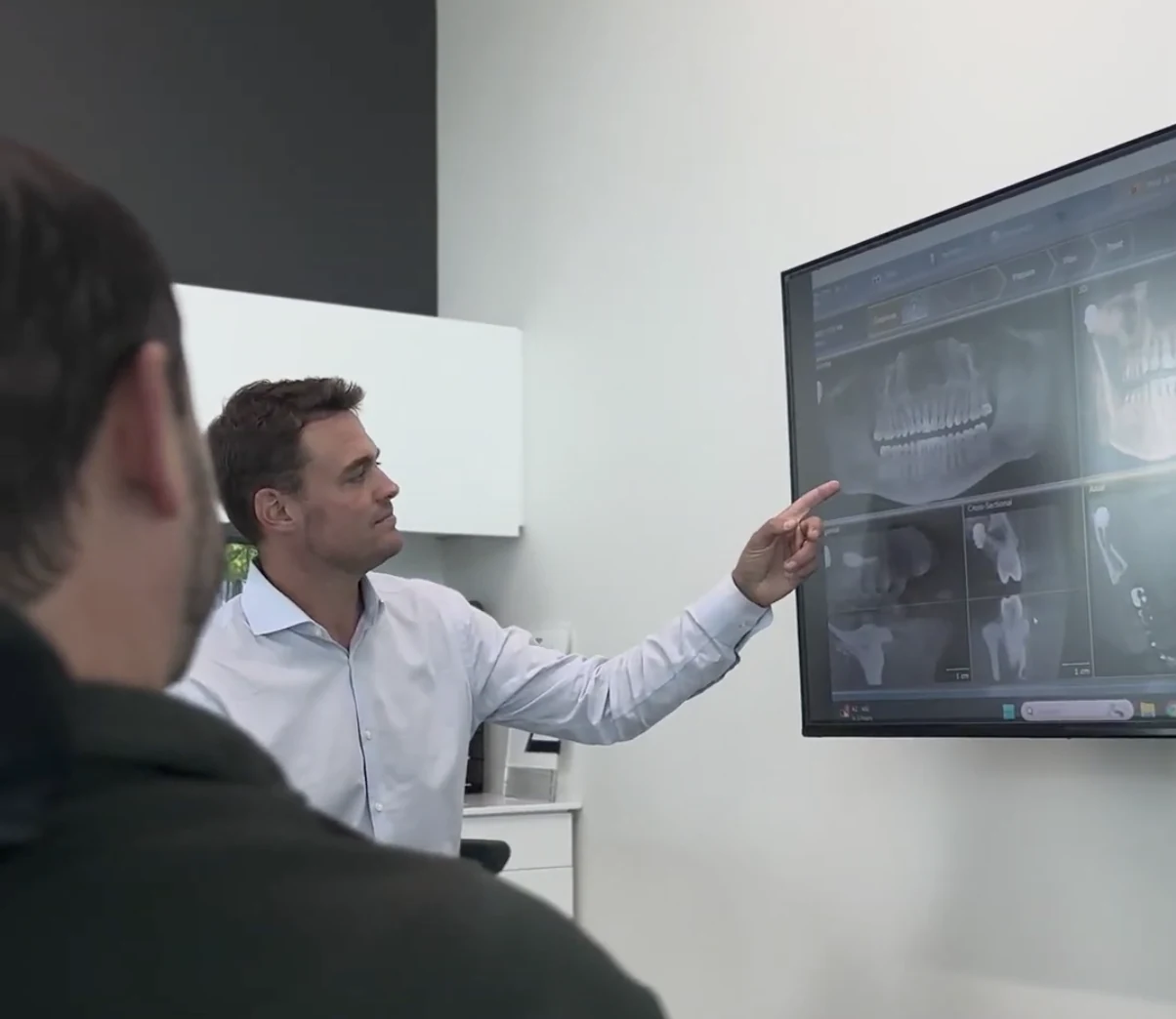 Dr. Robert E. Johnson reviewing dental imaging with a patient