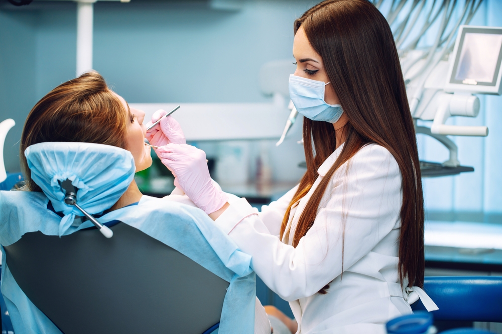 Dental assistant examining a patient's teeth at Plaza Pointe Dental Specialists