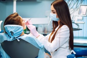 dental assistant examining woman's teeth
